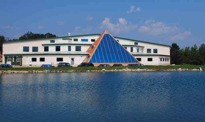 A great view of the front face of our new Beltane Hill facility as it reflects off
of our beloved swimming hole.